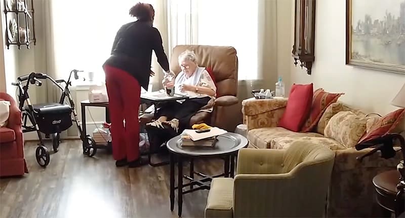 A nurse bringing medicine to an elderly woman in nursing care at Holly Hall Christian Retirement Community.